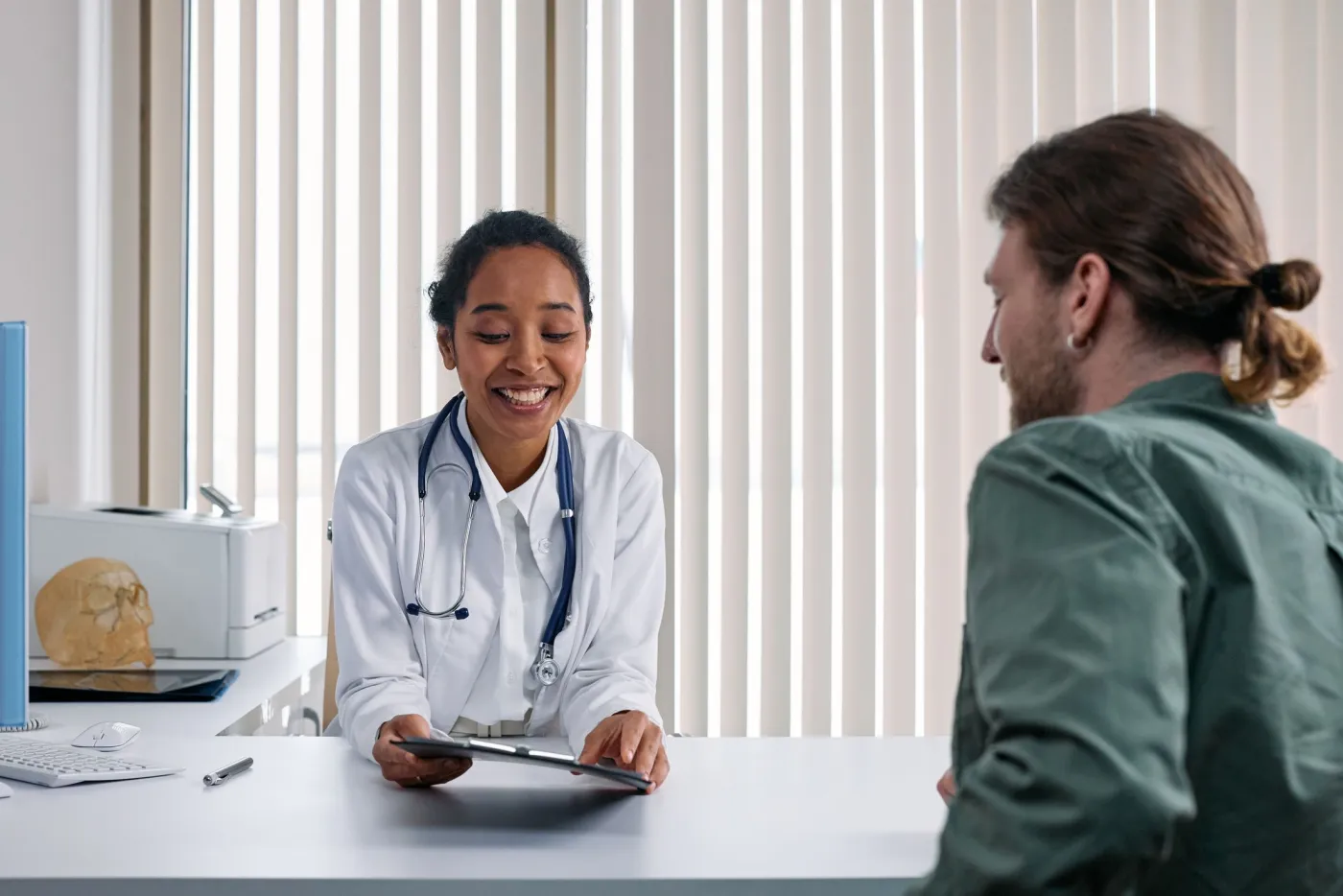A smiling doctor talking with a patient.