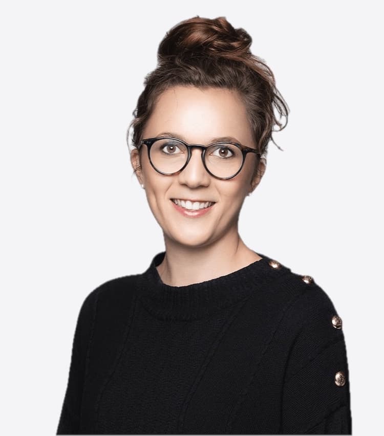 Mathilde Collin smiling, in a black jumper and round glasses