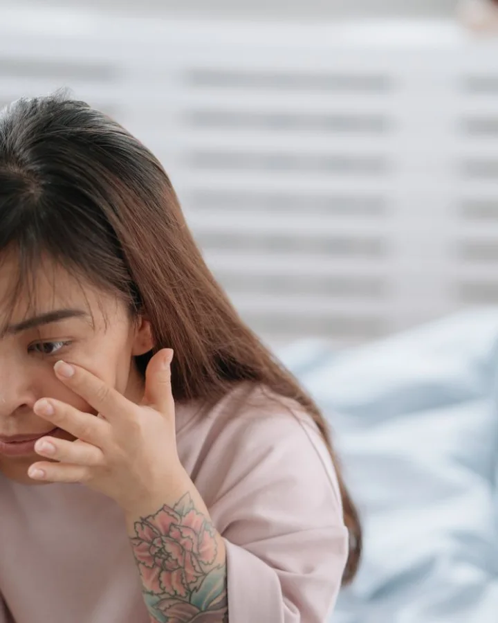 A woman rubbing her dry, tired eye